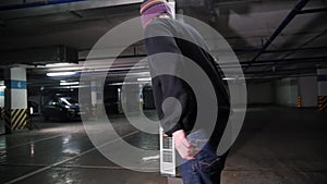 A young man skateboarding on his board in the parking lot. Skating around obstacles. Back view