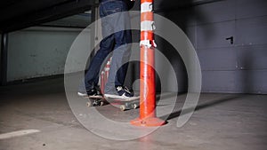 A young man skateboarding in the parking lot. Training his skateboarding skills skating around obstacles