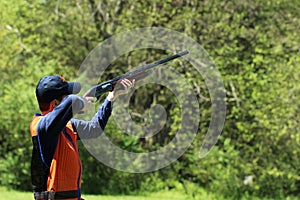 Young man skeet shooting