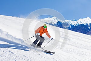 Young man in ski mask sliding fast while skiing