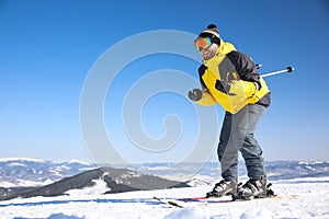 Young man skiing on hill, space for text. Winter vacation