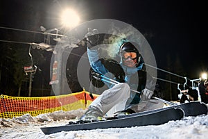 Young man skiing at ski resort at night.