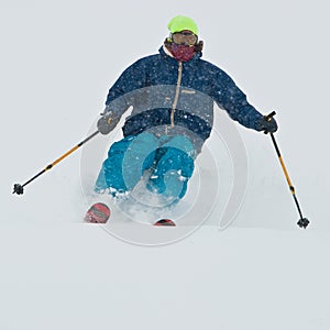 Young man skiing in snowstorm