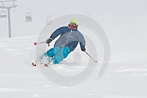 Young man skiing in snowstorm