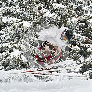 Young man on skis doing tricks with ski poles.