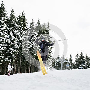 Young man on skis doing tricks at ski resort.