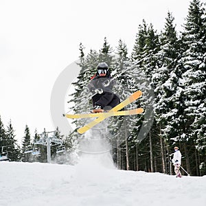 Young man on skis doing tricks at ski resort.