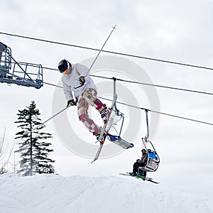 Young man on skis jumping in the air at ski resort.