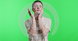 Young man slapping his cheeks, chroma key background