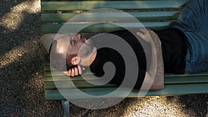 Young man sleep on a bench.