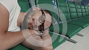 Young man sleeping at airport passenger terminal