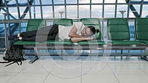 Young man sleeping at airport passenger terminal