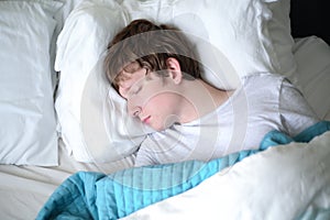 Young Man Sleeping in Bed