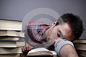 Young man sleeping on books