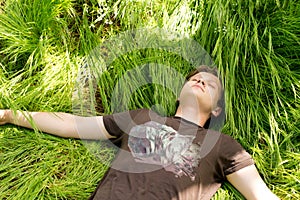 Young man sleeping in long green grass