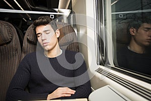 Young man sleeping while traveling on a train