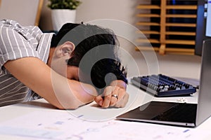 Young man sleepy, take a nap at work table, Overworked at night