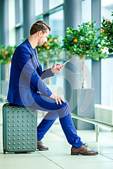 Young man with smart phone in airport. Caucasian man with cellphone at the airport while waiting for boarding