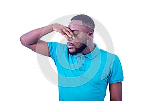 Young man smelling smelly and holding his breath with his fingers on his nose