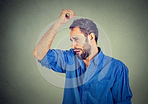 Young man, smelling, sniffing his armpit, something stinks, very bad, foul odor photo