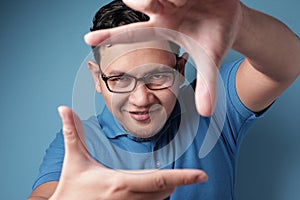 Young Man Smiling at Camera While Framing His Face With Hands