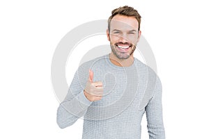 Young man smiling and giving a thumbs up