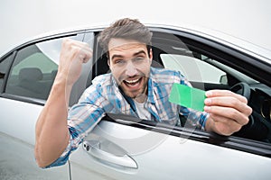 Young man smiling and holding card