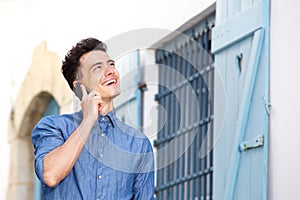 Young man smiling and listening to cell phone