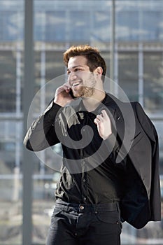 Young man smiling with mobile phone in the city