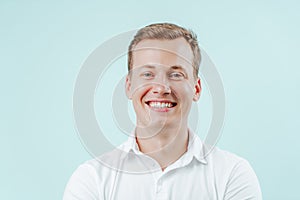 Young man smiling with natural white teeth in dental clinic on light background. Smile healthy teeth concept