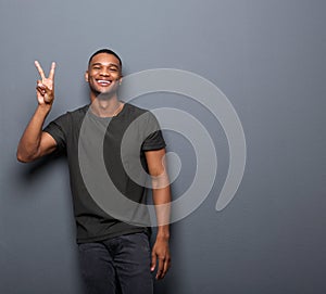 Young man smiling showing hand peace sign