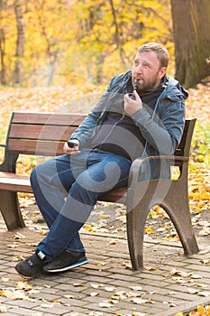 Young man smokes tobacco pipe in park