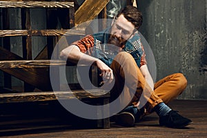 Young man smoking a cigar while sitting on the stairs