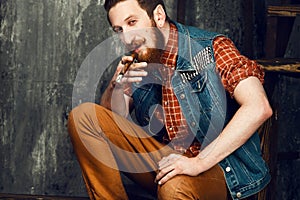 Young man smoking a cigar while sitting on the stairs