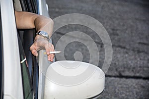 Young Man smoking cigarette while Driving