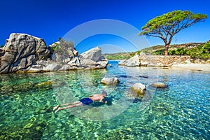 Young man snorkeling in green lagoon, Corsica France, Europe.