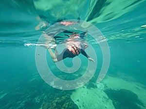 Young man snorkeling scuba diving with life jacket  at the Great Barrier Reef in the tropical