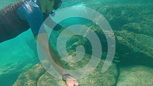 Young man snorkling in a beautiful blue sea and makes a selfie video