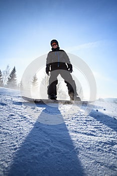 Young man snowboarding down a slope