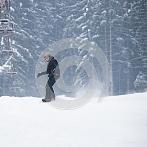 Young man snowboarding down a slope