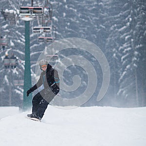 Young man snowboarding down a slope