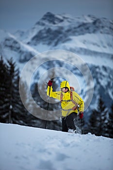 Young man snowshoeing in high mountains,