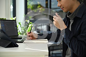 Young man software developers working with coded data on computer screen. Developing programming and coding technologies