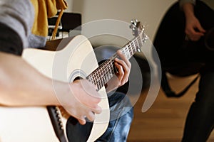 The young man is a soloist on an acoustic guitar photo