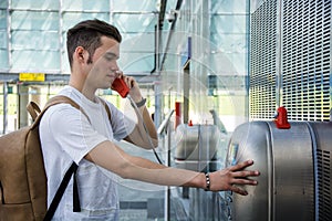 Young man speaking on public phone in station