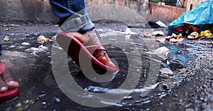 Young man splashing in dirty water in the countryside. Closeup leg`s shot