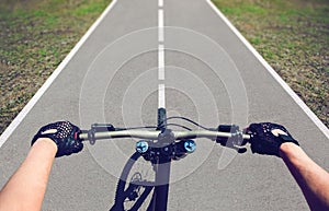 Young man-sportsman rides a mountain bike on an asphalt road