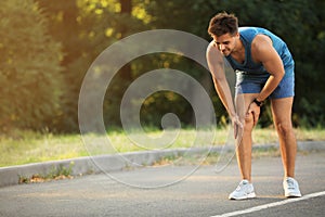 Young man in sportswear having knee problems