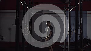 Young man in sportswear preparing to workout and clapping hands with magnesia in gym.