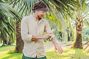 Young man spraying mosquito insect repellent in the forrest, insect protection